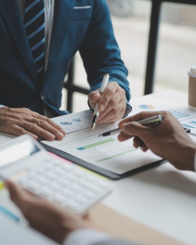 Financial analysts analyze business financial reports on a digital tablet planning investment project during a discussion at a meeting of corporate showing the results of their successful teamwork.